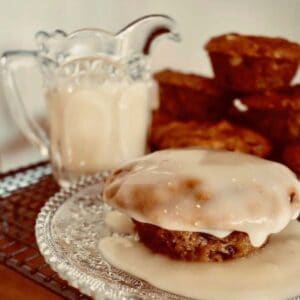 Carrot Christmas Pudding on plate with warm vanilla sauce poured over.