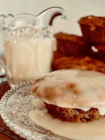 Carrot Christmas Pudding on plate with warm vanilla sauce poured over.