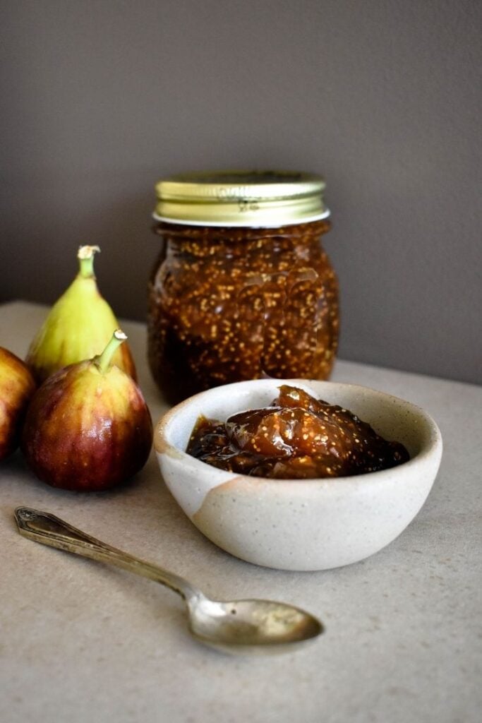 fig jam on bench with two fresh figs
