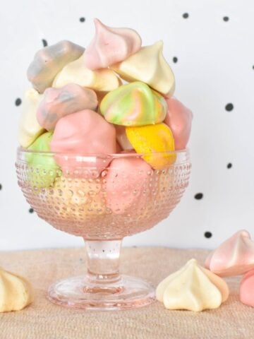 Meringue kisses piled high in glass dish.