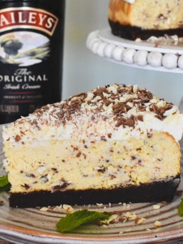 Bailey's Cheesecake Slice with Bailey's bottle in background.